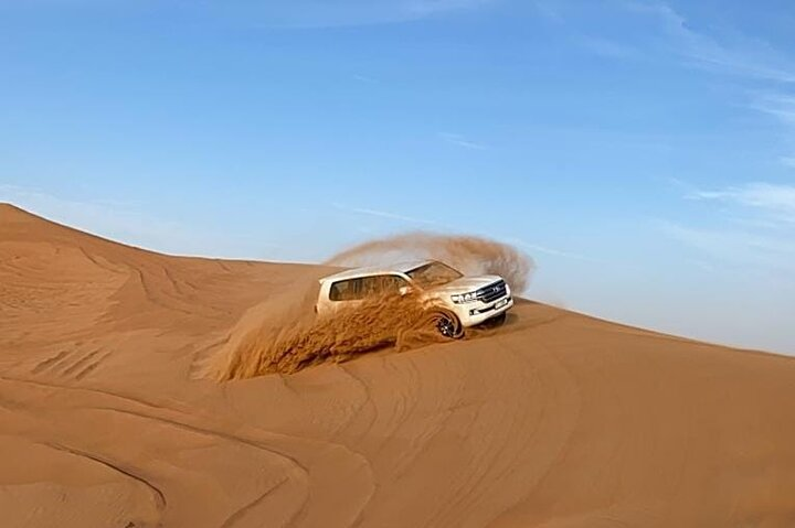 Experience the excitement of desert dune bashing where you’ll navigate majestic sand hills and enjoy breathtaking views as you journey through Dubai’s stunning red desert landscape.